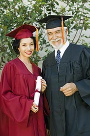 two adults in graduation cap and gowns