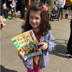 Child holding book at SUNY Broome Children's Fair