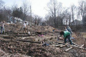 Student volunteers work an outdoor building project.